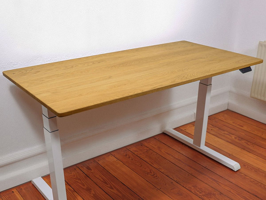 Höhenverstellbarer Schreibtisch - Eiche NaturPro White. Schrägansicht im Raum stehend. Fokus auf die ganze Platte, naturgeölt mit einer schönen Maserung. Keine Gegenstände auf der Platte.