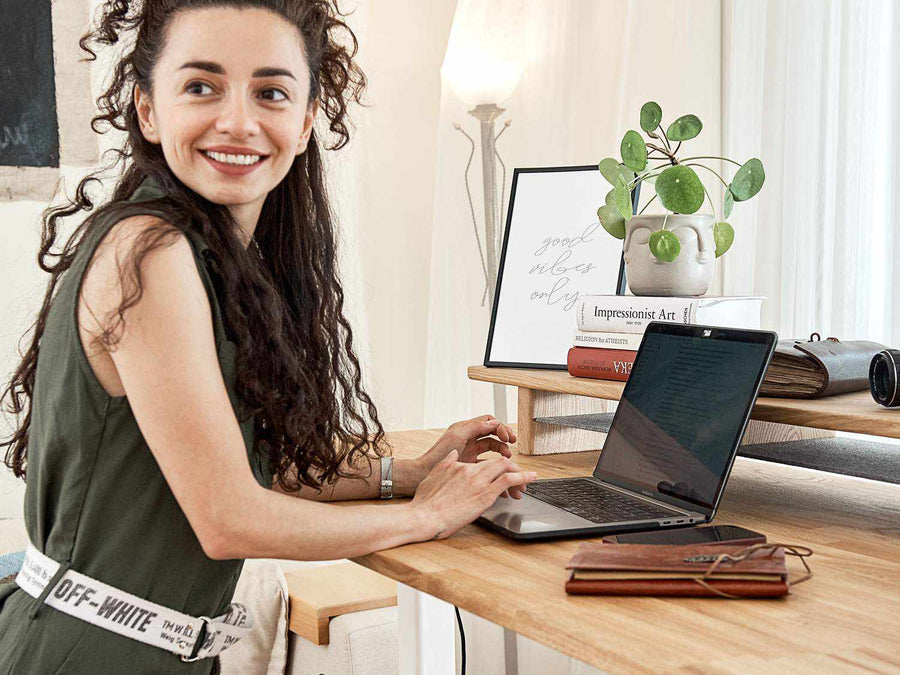 Höhenverstellbarer Schreibtisch mit Tischplatte aus naturbelassenem Eichenholz und weißem Gestell.