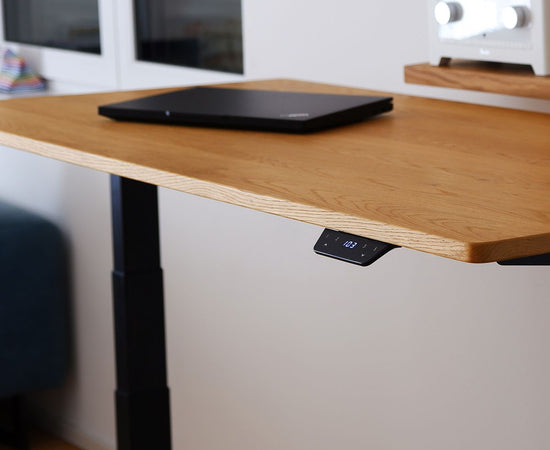 Höhenverstellbarer Tisch Eiche NaturPro, aufgestellt in einem Raum. Fokus auf den Smart Controller