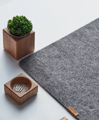 Weiche Schreibtischunterlage aus grauem Filz, schützt die Tischplatte und bietet eine angenehme Schreiboberfläche.