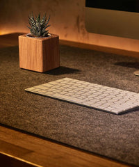 Weiche Schreibtischunterlage aus grauem Filz, schützt die Tischplatte und bietet eine angenehme Schreiboberfläche.